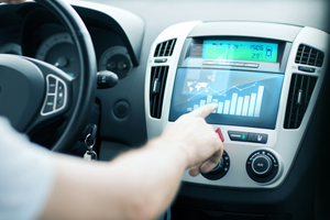 Driver using a touch-screen dashboard within his car.